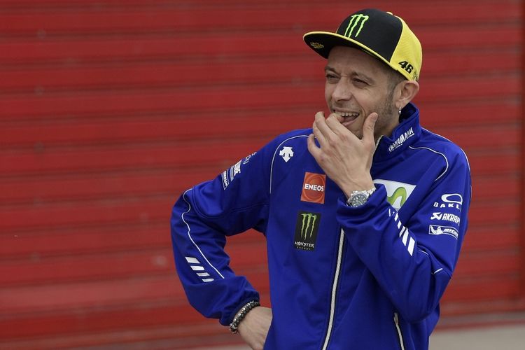 Pebalap Yamaha Movistar MotoGP asal Italia, Valentino Rossi, menungu pebalap binaannya di VR46 Riders Academy, Andrea Migno, di pit Autodromo Termas de Rio Hondo setelah balapan Moto3, Minggu (9/4/2017).