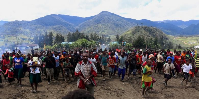 Warga bersama-sama memasuki lapangan Trikora untuk memulai acara adat bakar batu di Lapangan Trikora Distrik Ilaga, Kabupaten Puncak, Papua, Kamis (15/9/2016). Tradisi bakar batu merupakan salah satu tradisi terpenting di Papua yang berfungsi sebagai tanda rasa syukur, menyambut tamu, atau acara perdamaian setelah perang antar suku.