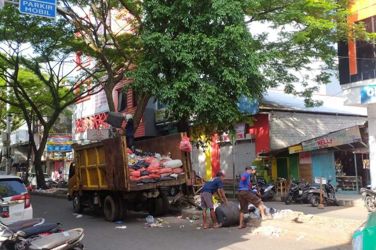 Petugas kebersihan mengfangkut sampah yang menumpuk di Jalan Sam Ratulangi kota Ambon, Rabu siang (18/1/2023)