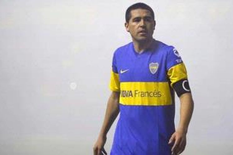 Reaksi gelandang Argentina milik Boca Juniors saat pertandingan semifinal pertama Copa Lbertadores melawan Universidad de Chile dihentikan akibat asap kembang api dari publik Stadion La Bombonera, pada 14 Juni 2012. Riquelme kembali ke Boca untuk kali ketiga, Jumat (8/2/2013), dan dikonfimasi sendiri oleh presiden klub, Daniel Angelici. 