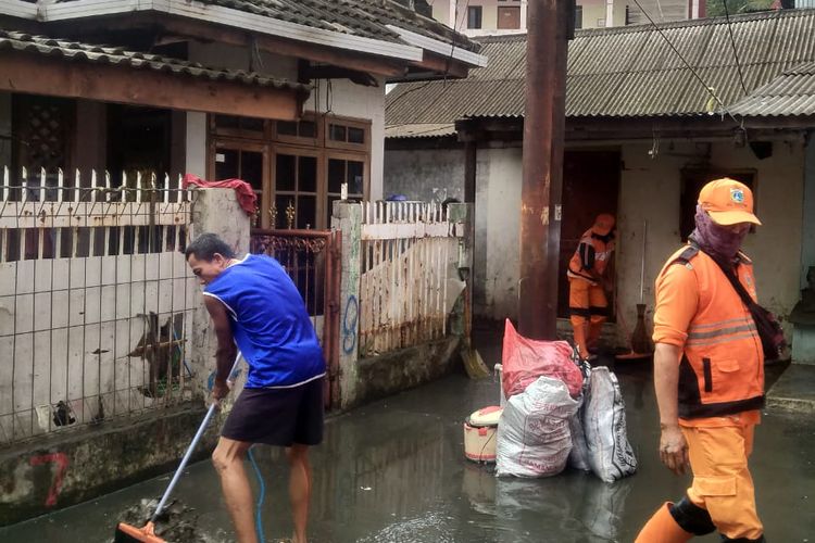 Pada Selasa (9/2/2021) siang, warga dan petugas mulai membersihkan lumpur akibat banjir yang menggenang di Cililitan, Jakarta Timur.
