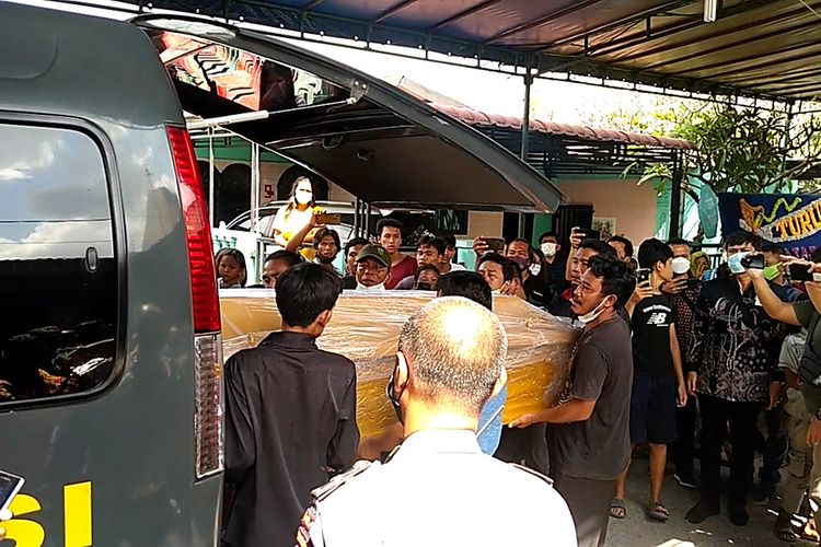 Sejumlah warga menurunkan jenazah Feri di dalam peti dari mobil ambulans milik RS Bhayangkara Medan di rumah duka di Jalan Krakatau, Aluminium I, Gang Asbes, Kelurahan Pulo Brayan Bengkel, Kecamatan Medan Timur pada Jumat (26/2/2021) pukul 10.30 WIB.