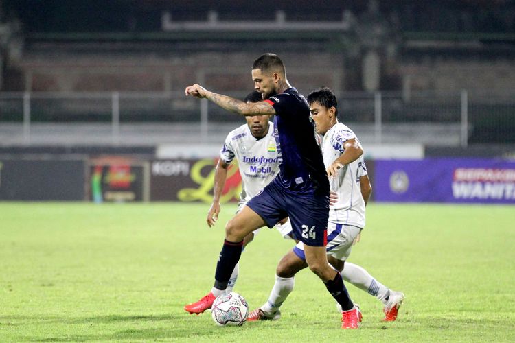 Pemain Arema FC Diego Michiels dijaga ketat 2 pemain Persib Bandung saat pertandingan pekan 30 Liga 1 2021 yang berakhir dengan skor 1-2 di Stadion I Gusti Ngurah Rai Denpasar, Rabu (9/3/2022) malam.