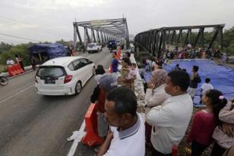 Warga menyaksikan dibukanya kembali Jembatan Comal Pantura, Pemalang, Jawa Tengah, di jalur Jakarta ke Surabaya, Kamis (24/7/2014). Lalu lintas untuk jalur Surabaya - Jakarta masih diarahkan ke jalan alternatif, karena sisi jembatan selatan masih belum selesai diperbaiki.