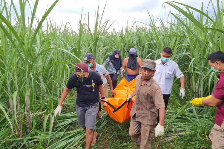 Petugas dibantu warga menggotong kantong jenazah berisi mayat perempuan dan bayinya yang ditemukan di ladang tebu Dusun Pluncing, Desa Siman, Kecamatan Kepung, Kabupaten Kediri, Jawa Timur, Rabu (29/3/2023).