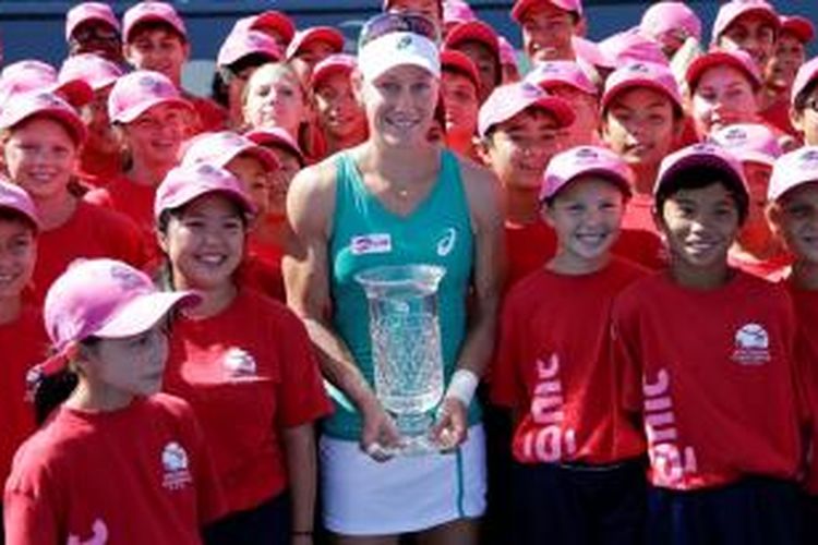 Petenis Australia, Samantha Stosur memegang trofi juara juara Southern California Open, dan berpose bersama ball kids, setelah memenangi laga final melawan Victoria Azarenka, di Carlsbad, Minggu (4/8/2013).