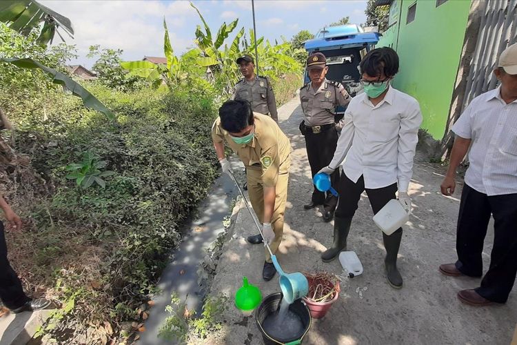 Petugas Dinas Lingkungan Hidup Kabupaten Bantul Mengambil Sampel Air di Irigasi Dusun Karangnongko, Desa Panggungharjo, Kecamatan Sewon Senin (15/7/2019)