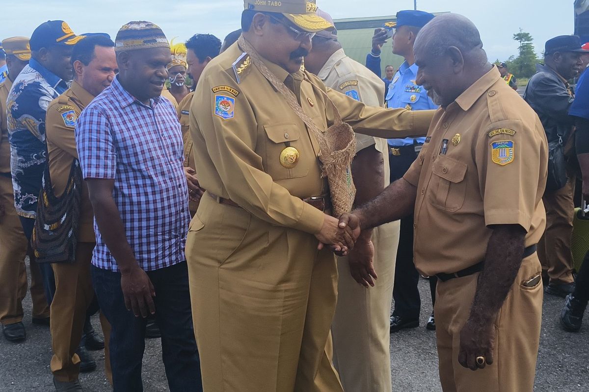 Gubernur Papua Pegunungan, John Tabo, bersalaman dengan pegawai di Pemda Biak Numfor, saat tiba membuka kegiatan Rapat Koordinasi Teknis dalam rangka membangun ekonomi yang ada di wilayah pegunungan dan pantai di Kabupaten Biak Numfor, Papua, Senin (14/7/2025).