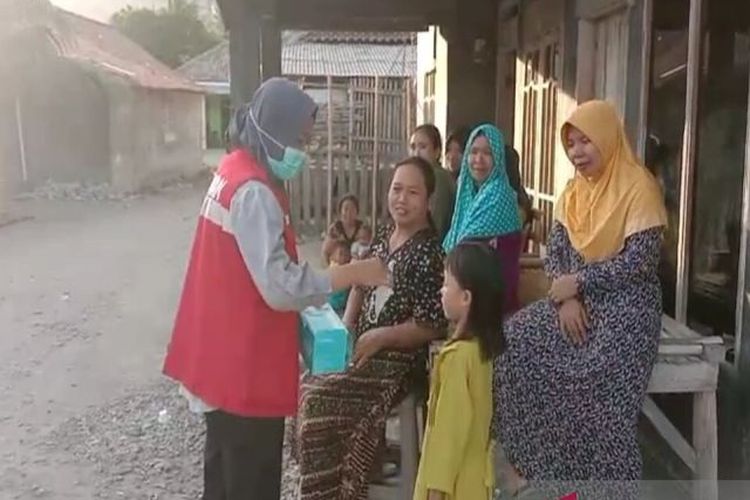 Petugas membagikan masker kepada warga yang terdampak abu vulkanik dari Gunung Anak Krakatau di Desa Pulau Sebesi, Kecamatan Rajabasa, Kabupaten Lampung Selatan, Provinsi Lampung.