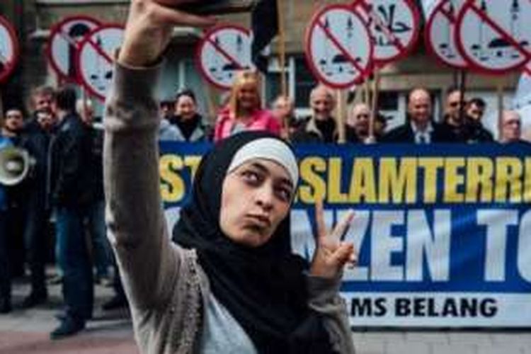 Salah satu aksi selfie Zakia Belkhiri di depan unjuk rasa kelompok anti-Islam di Belgia, Vlaams Belang.