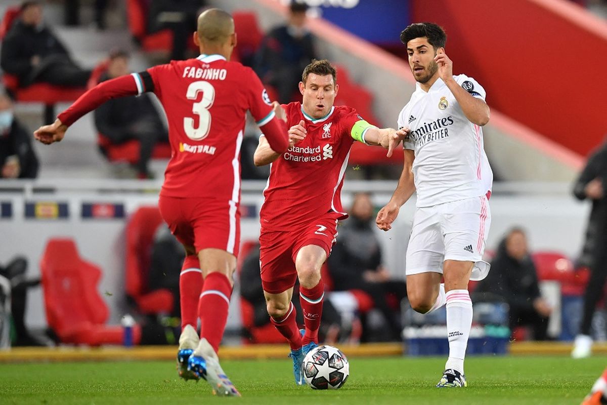 Gelandang Liverpool Fabinho (kiri) dan rekan setim James Milner (tengah) bersaing dengan gelandang Real Madrid Marco Asensio dalam pertandingan leg kedua perempat final Liga Champions antara Liverpool vs Real Madrid di Anfield Liverpool pada 14 April 2021.