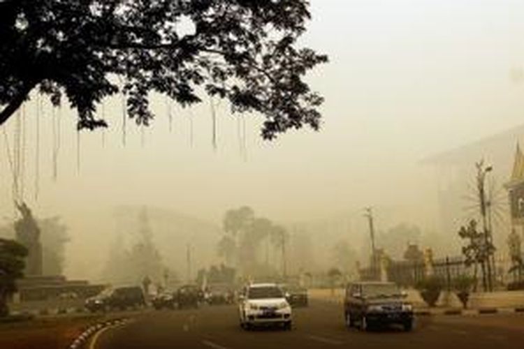 Kabut asap di Riau membuat kualitas udara di Kota Pekanbaru sangat buruk. Bahkan, beberapa kalangan meyakini kemarin merupakan hari terburuk dalam sejarah peristiwa kabut asap. Semua bangunan nyaris tak terlihat dari jarak 100 meter. Foto diambil Kamis (13/3/2014) pada pukul 15.30 di Tugu Nol Kilometer di tengah kota Pekanbaru, persis di depan kantor Gubernur Riau. 