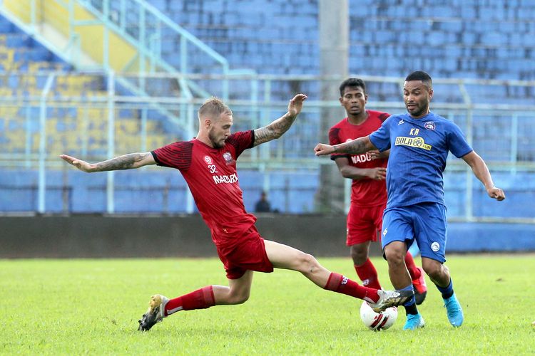 Pemain asing Arema FC, Bruno Smith dihalau pemain Madura United Jacob Pepper saat latih tanding yang berakhir dengan skor 2-2 di Stadion Kanjuruhan Kepanjen Kabupaten Malang, Jawa Timur, Senin (15/03/2021) sore.