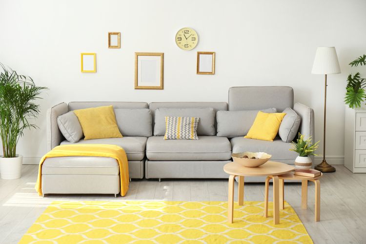 Ilustrasi ruang keluarga dengan perpaduan kuning dan abu-abu.