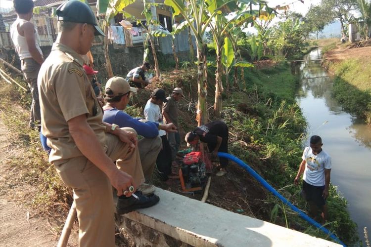 Petani bersama Pemdes Sukawening, Ganeas, Sumedang, Jawa Barat melakukan penyedotan air di saluran irigasi yang letaknya berada di bawah sawah, Selasa (2/7/2019). AAM AMINULLAH/KOMPAS.com