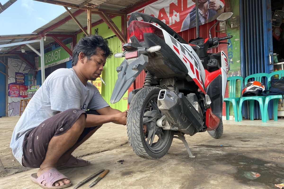 Ilustrasi proses tambal ban motor non-tubeless, masih menggunakan press karet