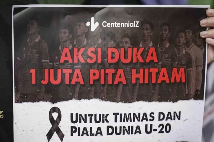 Anggota komunitas CentennialZ memegang poster saat melakukan Aksi Duka 1 Juta Pita Hitam di kawasan Senayan, Jakarta, Jumat (31/3/2023).