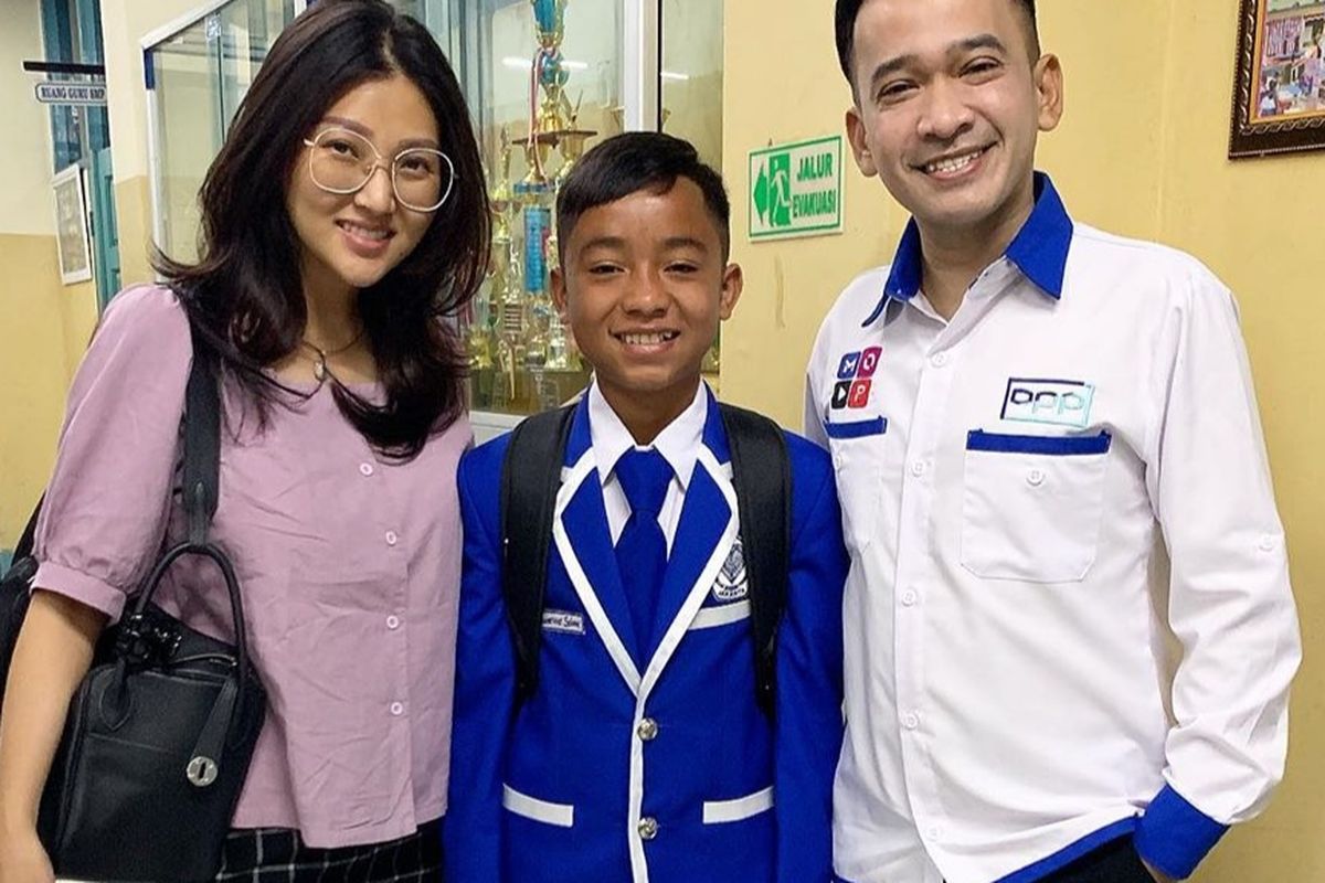 Betrand Peto diapit kedua orangtua asuhnya Ruben Onsu dan Sarwendah yamg mengantarkan ke sekolah hari pertama.