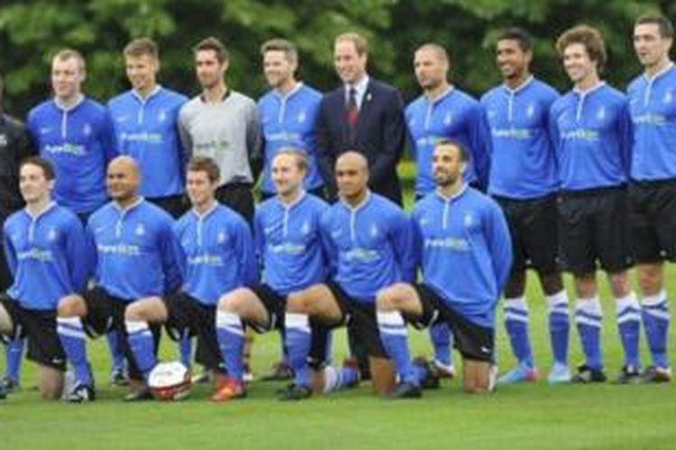 Pangeran William berfoto berseama tim Liga Amatir Southern sebelum pertandingan di istana Buckingham, London.