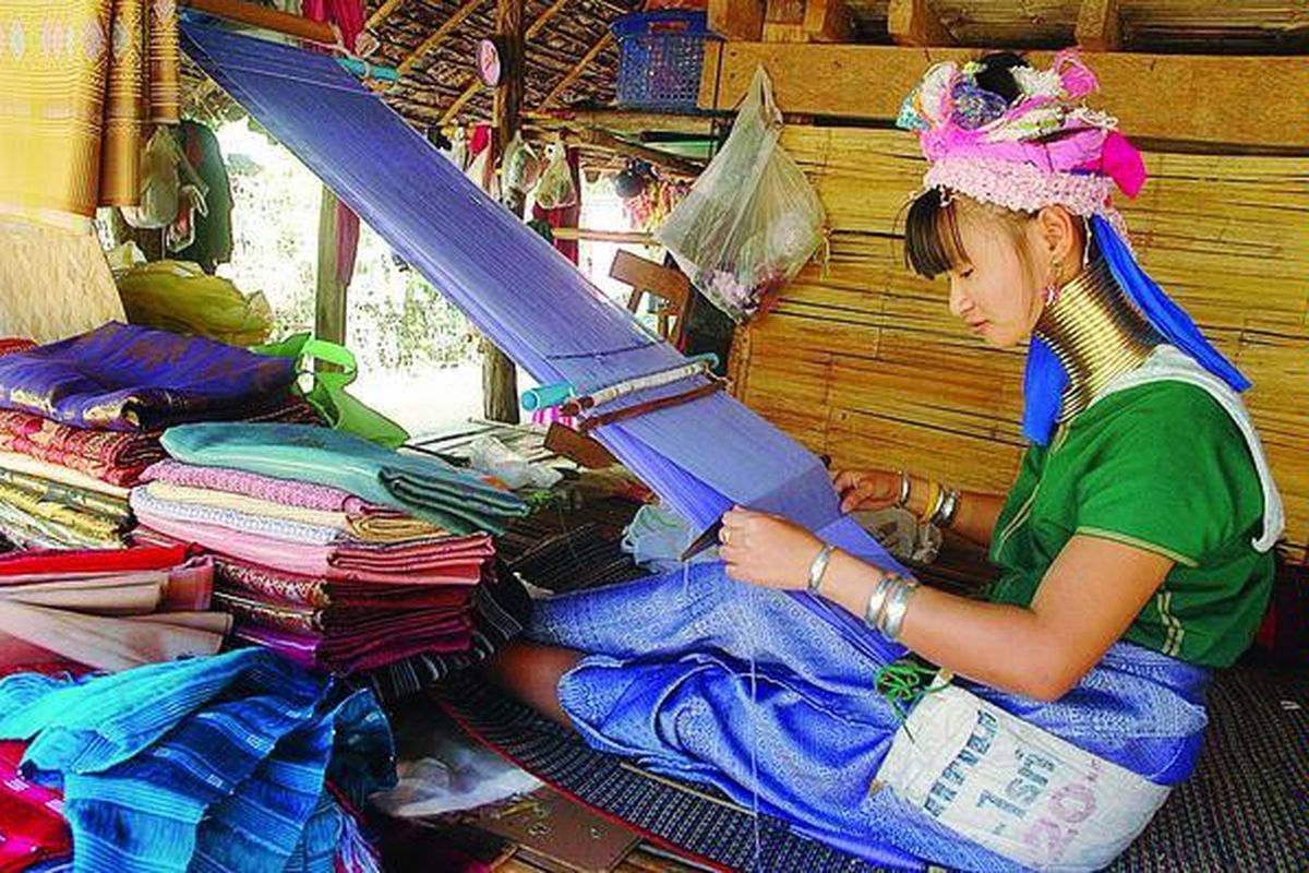 Seorang perempuan suku Karen menenun kain untuk dijual kepada wisatawan yang berkunjung ke permukiman mereka di wilayah Chiang Mai, Thailand, Jumat (3/12). Banyak wisatawan tertarik untuk mengetahui budaya dan kebiasaan hidup warga suku 