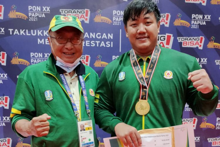 Dimas Septo Anugraha (kanan), usai meraih medali emas di cabor gulat gaya bebas kelas 125 kilogram PON XX Papua.