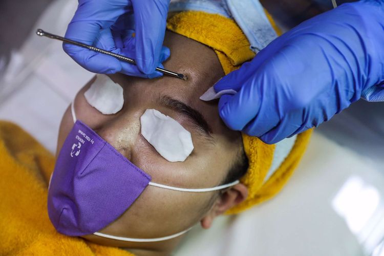 Dokter Spesialis Kulit dan Kelamin, dr. Rahma Evasari menggunakan masker, pelindung wajah serta APD saat melakukan perawatan kulit wajah di RSIA Tambak, Jakarta Pusat, Senin (22/6/2020). Perawatan wajah dengan protokol kesehatan tetap menjadi prioritas klinik kecantikan guna mengantisipasi penularan COVID-19.