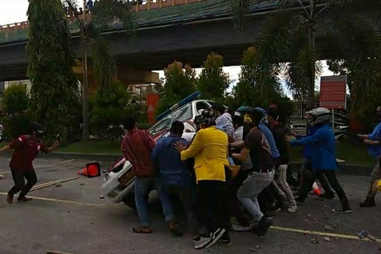 Massa demonstrasi merusak dan menggulingkan mobil polantas saat melakukan aksi penolakan UU Cipta Kerja di Kantor DPRD Riau di Kota Pekanbaru, Riau, Kamis (8/10/2020).