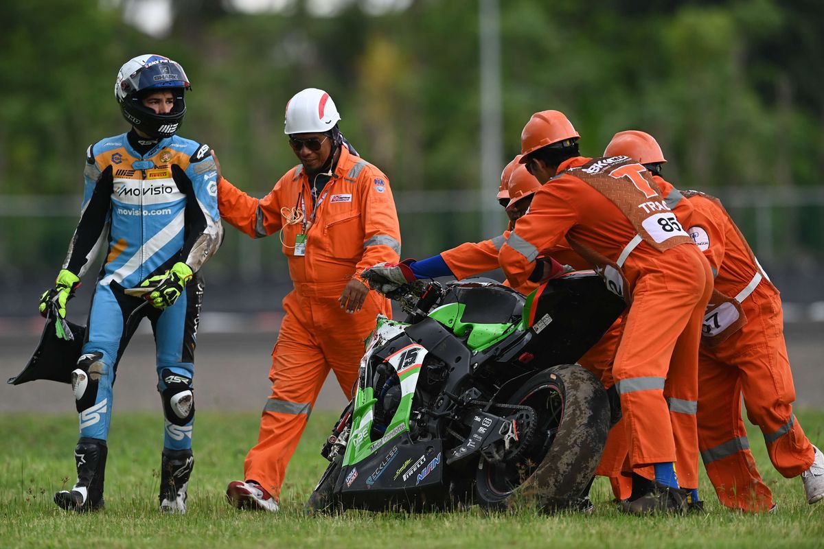 Sejumlah marshal membantu mengangkat sepeda motor pebalap TPR OUTDO Pedercini Racing Oliver Konig (kanan) yang terjatuh dalam race 1 World SBK seri Indonesia 2021 di Pertamina Mandalika International Street Circuit, Lombok Tengah, Nusa Tenggara Barat (NTB), Minggu (21/11/2021). Pebalap tim Pata Yamaha With Brixx World SBK Toprak Razgatlioglu berhasil menjadi juara dunia WSBK 2021.