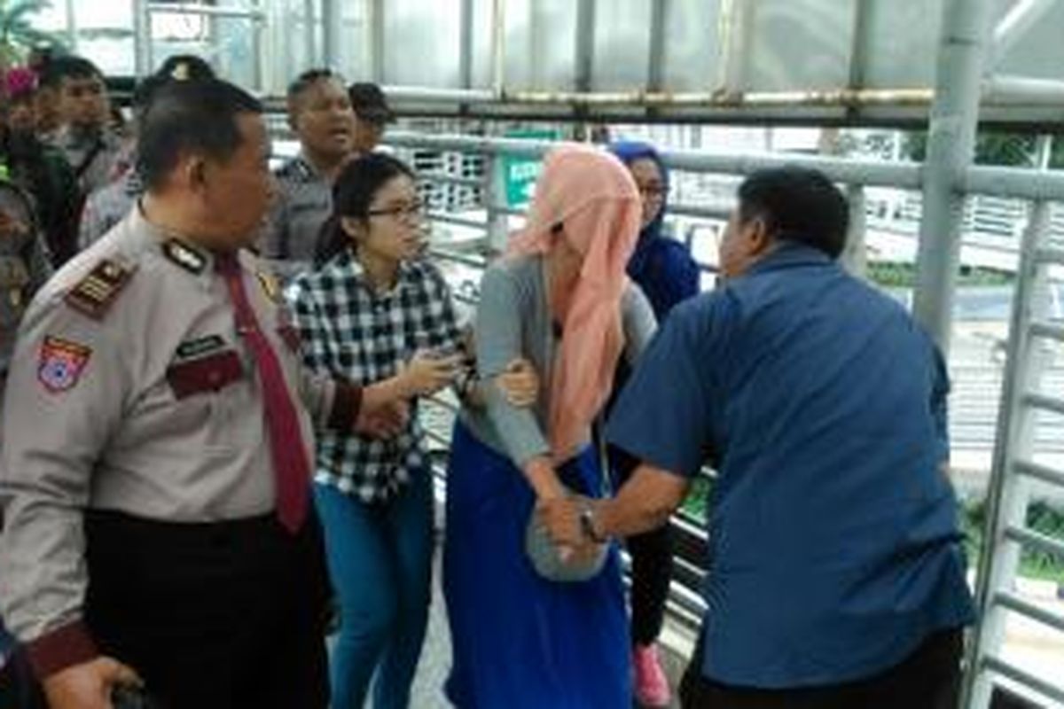 Petugas keamanan dari kepolisian dan TNI berupaya membujuk turun perempuan muda yang diduga hendak loncat dari JPO Kuningan Madya, Kuningan, Jakarta Selatan, Jumat (24/4/2015)