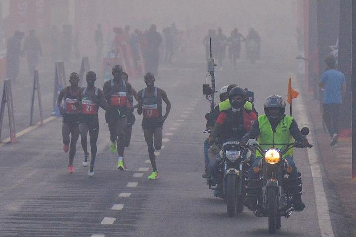 Peserta Maraton di New Delhi, India, berlari menembus asap polusi di jalan, Minggu (19/11/2017). (The Guardian)