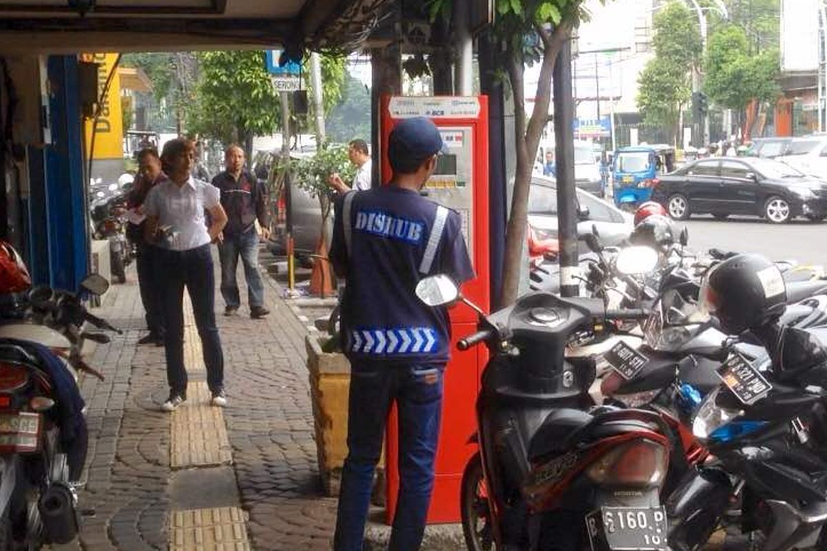Seorang petugas sedang mendaftarkan kendaraan yang hendak parkir di Jalan Sabang, Jakarta Pusat, ke mesin parkir meter, Kamis (3/5/2017).