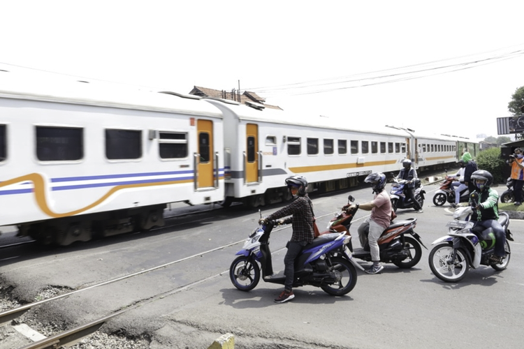 Ilustrasi pengendara menunggu kereta api melaju di perlintasan