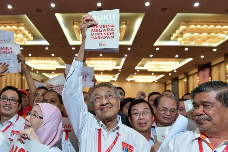 Gambar ini diambil pada 8 Maret 2018 menunjukkan mantan Perdana Menteri Malaysia  yang juga kandidat calon Perdana Menteri dari oposisi, Mahathir Mohamad (tengah) membawa 200 halaman manisfesto pemilu oleh 4 partai koalisi dalam Pakatan Harapan di Shah Alam.