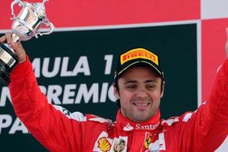 Pebalap Ferrari asal Brasil, Felipe Massa, mengangkat trofi di atas podium sirkuit Catalunya, setelah berhasil finis ketiga, Minggu (12/5/2013).