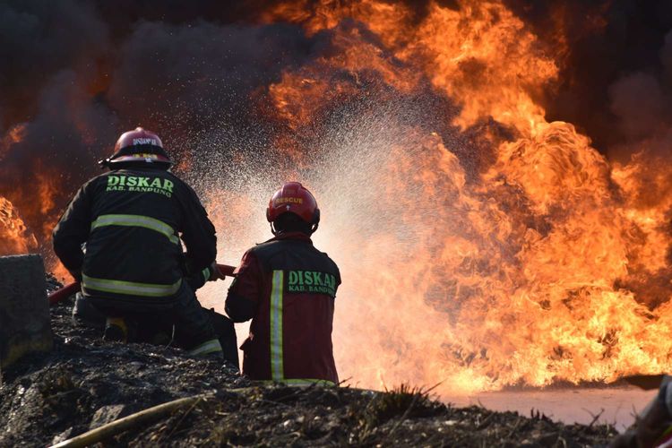 Tampak petugas pemadam kebakaran berupaya memadamkan api dalam kebakaran pipa minyak pertamina di Jalur KCIC yang berlokasi di KM 130, Kampung Mancong, Kelurahan Melong, Cimahi Selatan, Jawa barat, Selasa (22/10/2019).