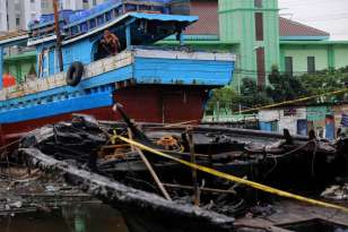 Seorang warga melihat bangkai kapal Zahro Express dipindahkan ke Docking Kapal Perikanan di Muara Angke, Jakarta Barat, Kamis (5/1/2017). Kapal Zahro Express yang sedang berlayar dari Pelabuhan Muara Angke menuju Pulau Tidung mengalami kebakaran pada Minggu (1/1/2017). Sedikitnya 23 penumpang tewas, beberapa luka-luka, dan sekitar 17 orang belum ditemukan.