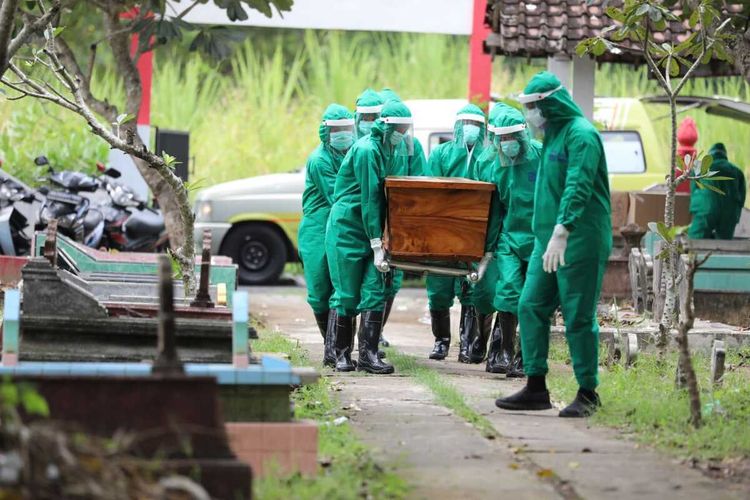 DIMAKAMKAN—Nampak petugas mengangkat peti jenazah korban berinisial A yang meninggal berstatus pasien dalam pegawasan Covid-19 setelah dirawat beberapa hari di RSUD dr. Soedono Madiun, Rabu (29/4/2020) siang.