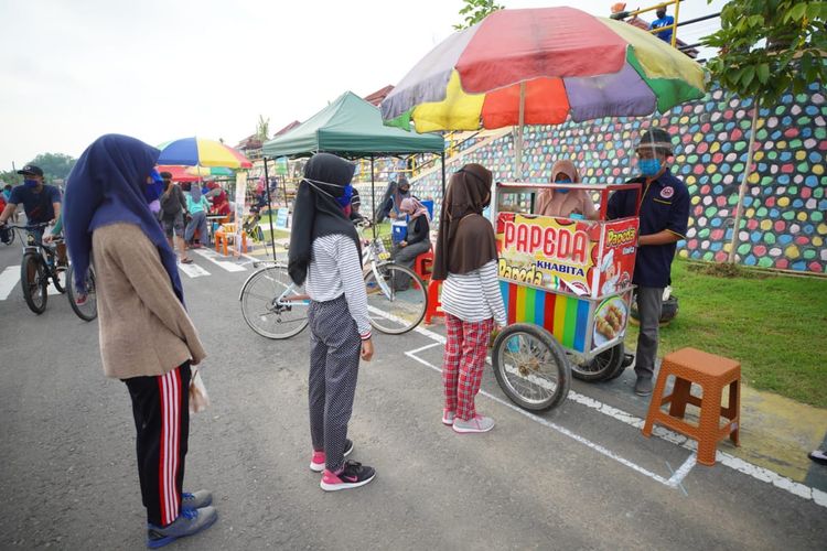 Warga tertib antri dengan memperhatikan jaga jarak di Sunday Market