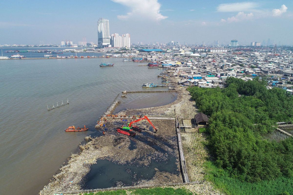 Petugas membersihkan lautan sampah yang menumpuk di kawasan Teluk Jakarta, Muara Angke, Jakarta Utara, Minggu (18/3/2018). Pencemaran limbah domestik rumah tangga di Teluk Jakarta ini memenuhi perairan seluas 7.500 meter persegi.