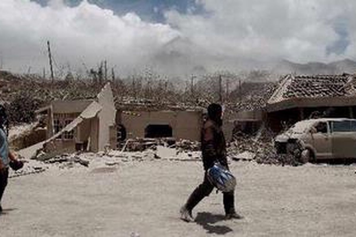 Warga melintas di antara puing rumah warga yang hancur akibat Letusan Gunung Merapi di Dusun Kinahrejo, Desa Umbulharjo, Cangkringan, Sleman, DI Yogyakarta, Rabu (27/10/2010).