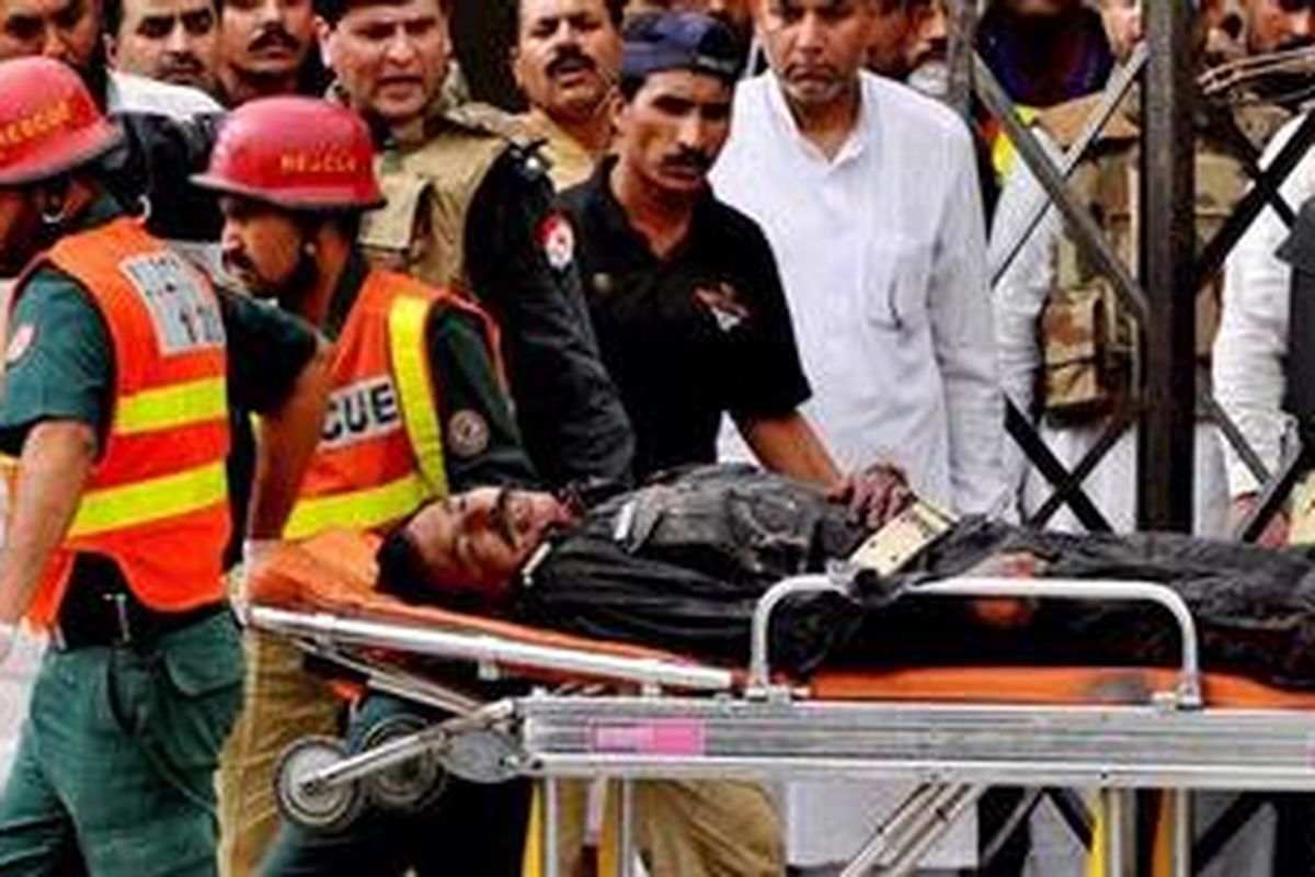 Petugas SAR melakukan pertolongan terhadap polisi yang terluka akibat serangan kelompok tidak dikenal terhadap dua masjid di Lahore, Pakistan.