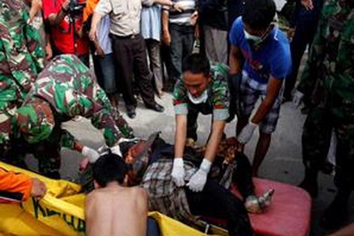 Petugas memindahkan jenazah korban gempa yang tiba di RS. DR. M Djamil, Padang, Sumatera Barat, Jumat (2/10). Sekitar 500 orang dinyatakan meninggal dan ribuan rumah hancur akibat peristiwa ini. 