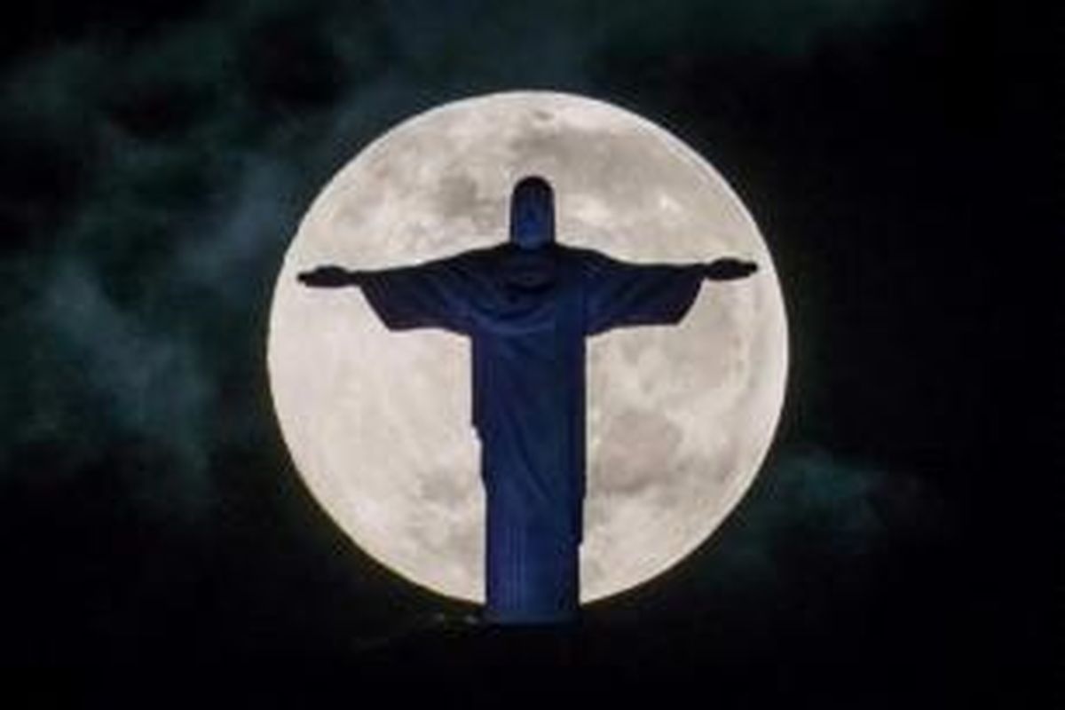 Bulan purnama dengan latar depan patung Kristus Penebus di atas bukit Corcovado di Rio de Janeiro, Brasil, 25 Mei 2013. Paus Francis akan mengunjungi Rio de Janeiro selama acara World Youth Day pada 23-28 Juli.