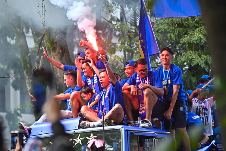 Pawai juara Persib Bandung ketika melintasi Jl Wastukencana Kota Bandung, pada Minggu (25/5/2025), Edo Febriansah memegang flare tanda perayaan dimulai. 