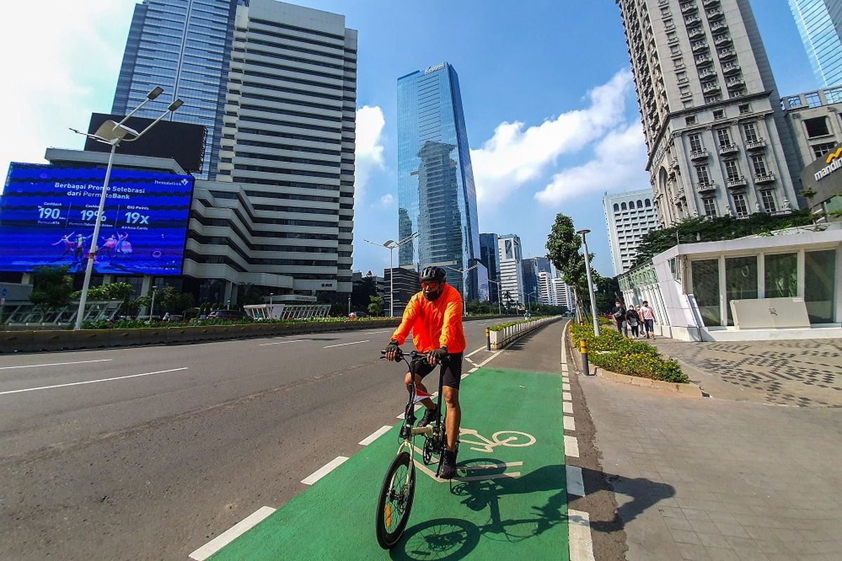 Warga bersepeda di Jalan Jenderal Sudirman, Jakarta, Minggu (26/9/2021), di tengah penerapan Pemberlakuan Pembatasan Kegiatan Masyarakat (PPKM). 