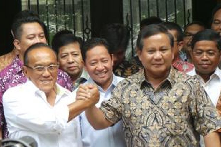 Bakal calon presiden dari Partai Golkar, Aburizal Bakrie (kiri), dan bakal capres dari Partai Gerindra, Prabowo Subianto (kanan), berpegangan tangan saat keduanya bertemu di kediaman Aburizal di Jakarta, Selasa (29/4/2014).