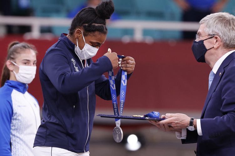 Komite Olimpiade Internasional (IOC) Thomas Bach menyerahkan medali perak kepada Sarah Leonie Cysique dari Prancis saat upacara penyerahan medali untuk cabang judo putri -57kg pada Olimpiade Tokyo 2020 di Nippon Budokan di Tokyo pada 26 Juli 2021.