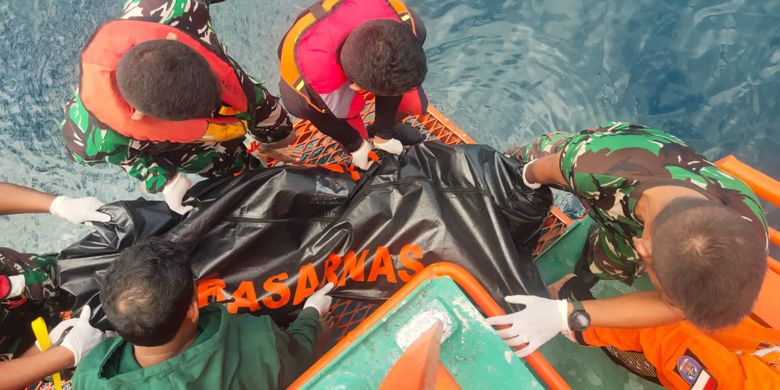 This handout picture taken and released on July 21, 2022 by Indonesia's National Search And Rescue Agency (BASARNAS) shows a rescue team moving victim's bodies after a ferry sank in bad weather in waters off Indonesia's Ternate island. The KM Cahaya Arafah capsized in waters off Indonesia's Ternate island on July 18, prompting a search and rescue operation for 13 missing people. (Photo by Handout / BASARNAS / AFP) 