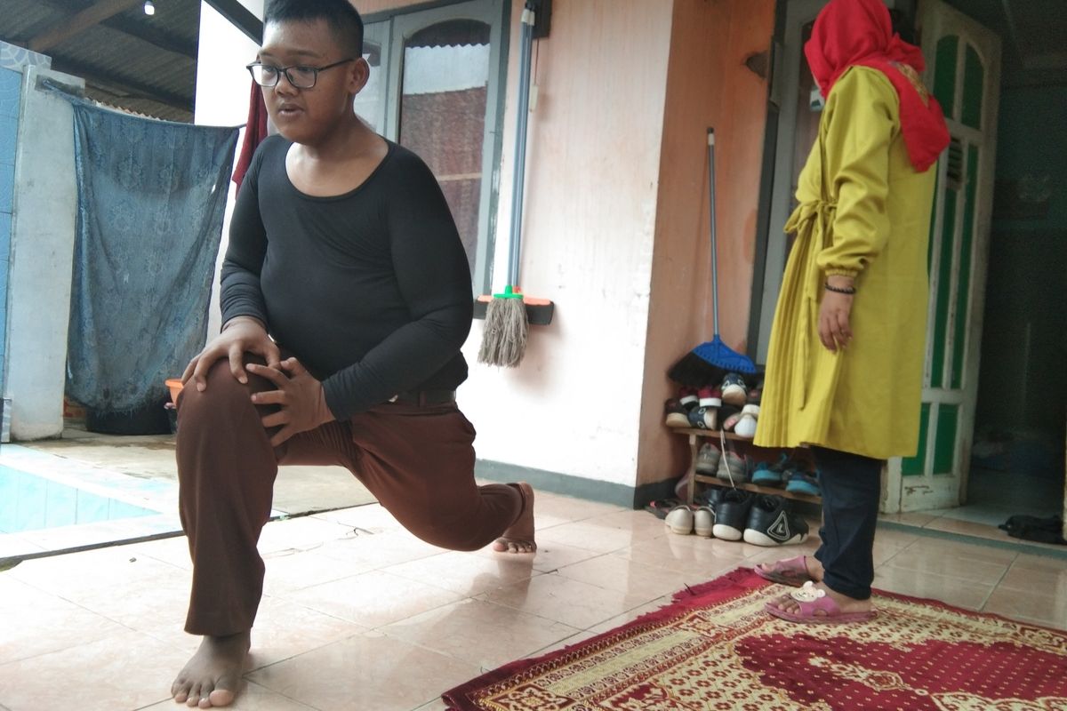 Arya Permana (14) saat melakukan olahraga ringan di rumahnya, Desa Cipurwasari, Kecamatan Tegalwaru, Kabupaten Karawang, Jumat (24/1/2020).
