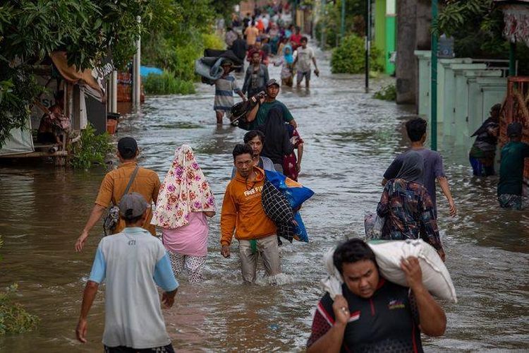 Warga meninggalkan rumah mereka yang terendam banjir akibat jebolnya tanggul Sungai Jratun-Wulan, di Desa Undaan Kidul, Kecamatan Karanganyar, Kabupaten Demak, Jawa Tengah, Kamis (8/2/2024).